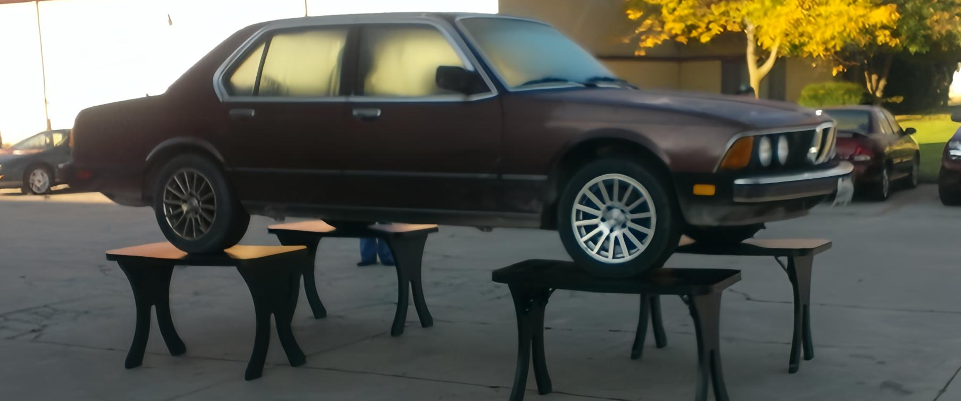 Car supported by multiple laminate tables demonstrating strength and durability